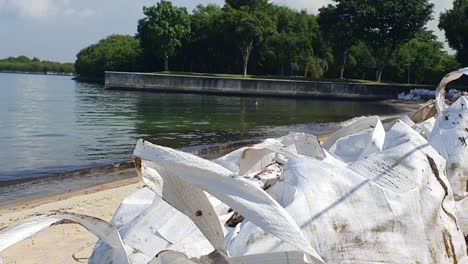 Tilt-video-of-big-bags-containing-oil-soaked-sand-on-Lazarus-Island,-Singapore