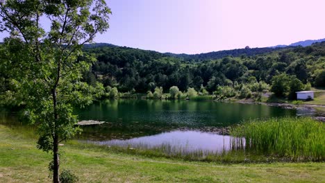 Un-Pintoresco-Lago-Ubicado-En-Las-Exuberantes-Montañas-Verdes-De-Crimea,-Bañado-Por-El-Cálido-Resplandor-De-Un-Día-Soleado