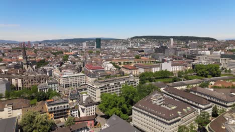 Drone-flying-up-and-over-the-city-of-Zürich-in-Switzerland-towards-Prime-Tower-on-a-hot-summer-day