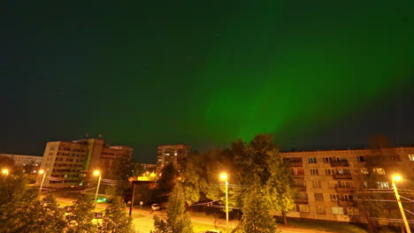 Northern-lights-above-city-suburbs,-time-lapse-view