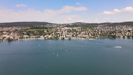 Drone-flyover-shot-over-Lake-Zürich-in-Switzerland-towards-Zollikon