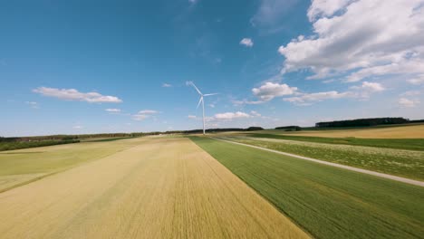 Agriculture-fields-and-wind-turbine,-aerial-FPV-view