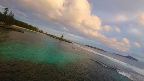 Flache-Riffe-Bei-Sonnenuntergang-Als-Orangefarbenes-Leuchten-Auf-Wolken-Auf-Den-Norfolkinseln,-FPV-Drohne