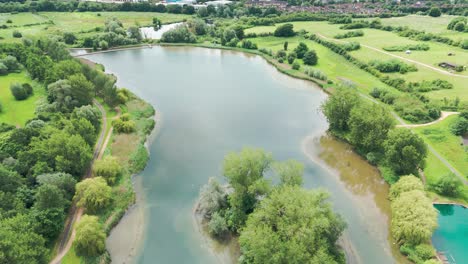 Vista-De-Perfil-Del-Parque-Wicksteed-Durante-El-Día-Soleado-Con-Reflejo-Del-Cielo-En-El-Agua-En-Inglaterra