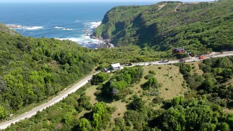 Vista-Aérea-Del-Tractor-Tirando-De-La-Casa-Al-Otro-Lado-De-La-Carretera-En-Chiloé,-Chile.