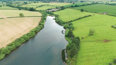 Forward-moving-drone-shot-of-river-in-Cransley-reservoir-in-England