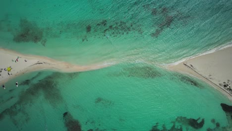 A-stunning-sandbar-in-clear-turquoise-waters-with-people-relaxing-on-the-beach,-aerial-view