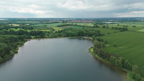 Aerial-pan-shot-of-river-in-Cransley-reservoir-in-England-on-a-cloudy-day