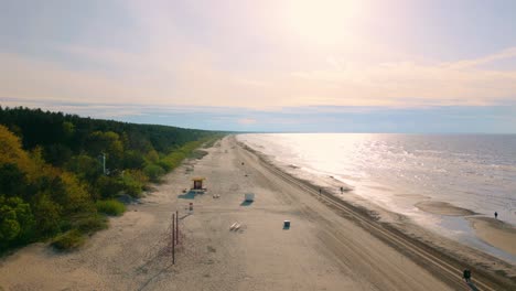 Baltic-beach-coastline-with-sea,-forest-and-beach-drone-crane-up-at-Jurmala-Resort-beach