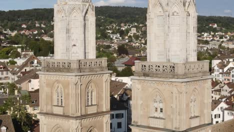 Toma-De-Drones-Ampliada-Volando-Alrededor-De-Las-Torres-De-La-Catedral-De-Grossmunster-En-Zurich,-Suiza