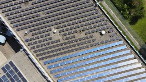 Spinning-Drone-shot-over-and-above-solar-panels-on-roof-of-industrial-building-in-Zürich-Switzerland