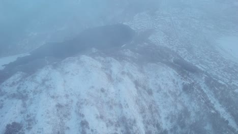 Thick-cloud-mist-or-fog-above-snow-covered-town-of-Bergen-Norway,-aerial-overview