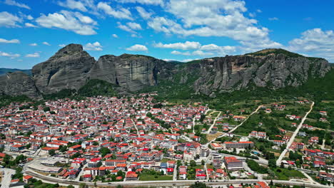 Establishing-drone-shot-moving-toward-the-Meteora-city,-sunny-day-in-Greece