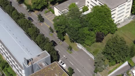 Top-down-drone-shot-following-car-driving-on-city-road-in-Zürich-Switzerland