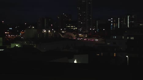 Timelapse-of-Brisbane-city-at-night,-showcasing-traffic-lights-and-passing-trains-against-a-backdrop-of-illuminated-buildings