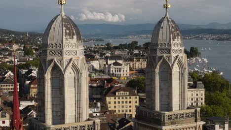 Vergrößerte-Drohnenaufnahme-Eines-Fluges-In-Richtung-Der-Türme-Der-Großmünster-Kathedrale-Und-Des-Opernhauses-In-Zürich,-Schweiz