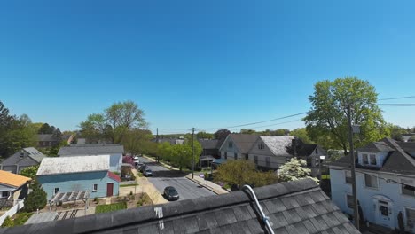 Aerial-flyover-neighborhood-with-solar-panels-on-roof-during-sunny-day-in-american-suburb