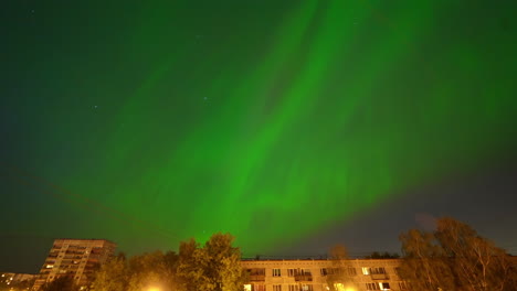 Vibrant-green-Aurora-borealis-over-cityscape,-night-time-lapse