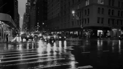 Toma-En-Cámara-Lenta-En-Blanco-Y-Negro-Del-Tráfico-En-La-Sexta-Avenida-Durante-Una-Tarde-Lluviosa-En-Manhattan,-Nueva-York