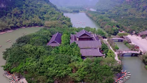 Serene-aerial-view-of-a-temple-surrounded-by-lush-greenery-in-Tam-Coc,-Ninh-Binh,-Vietnam