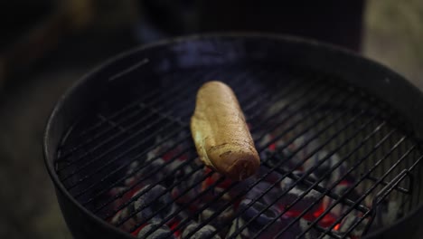 A-single-sausage-being-grilled-on-a-barbecue-with-grill-marks