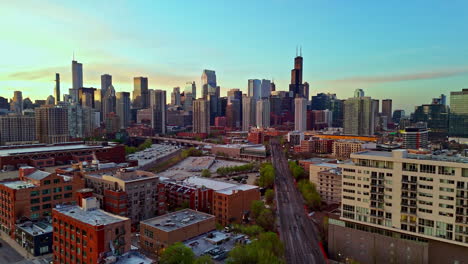 Drone-flying-over-the-cityscape-and-railway-of-River-West,-sunrise-in-Chicago