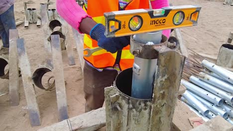 African-technician-leveling-and-adjusting-concrete-pile-frame-mould-and-support-for-solar-PV-concrete-pile