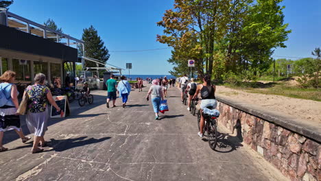 People-walking-and-biking-on-a-sunny-day-at-Vecaki-Beach-in-Latvia