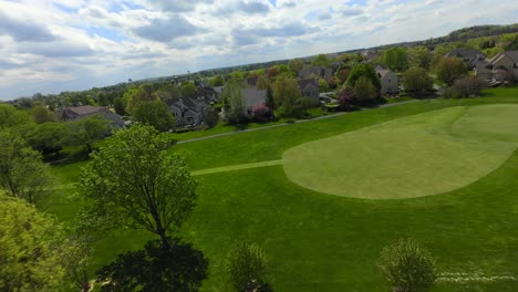 FPV-Drohnenflug-über-Einen-Golfplatz-Mit-Grünem-Rasen-Und-Sand-In-Einer-Amerikanischen-Stadt