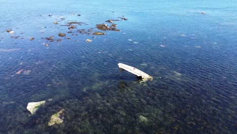 Parts-of-a-metal-ship-wreck-poking-out-of-calm-shallow-sea