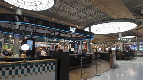 Waiting-passengers-at-the-wide-selection-of-Charles-de-Gaulle-Airport-public-departure-terminal's-eateries-and-bars-in-Paris,-France