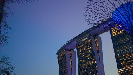 Vista-Del-Jardín-Junto-A-La-Bahía-Con-El-Edificio-Marina-Bay-Sand-Singapur-Por-La-Noche