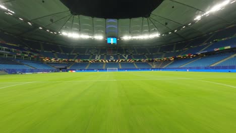 HSV-Stadium-FPV-Drone-under-flood-lights-traveling-over-goal-and-green-pitch