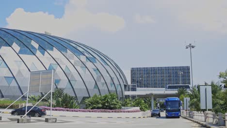 Vista-Del-Aeropuerto-Jewel-Changi-De-Singapur-Desde-El-Exterior-Con-Actividad-De-Autobuses-Turísticos-Y-Trenes-Del-Aeropuerto.