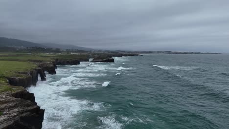 As-Catedrais-,-with-tide-in-waves-crashing-on-rocks-Cathedrals-beach-Northern-Spain-drone,aerial