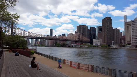 Frau-Sitzt-Mit-Blick-Auf-Manhattan-Und-Den-East-River-Von-Roosevelt-Island