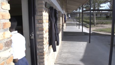 School-girl-entering-classroom-on-a-sunny-day-in-Rwanda,-Africa