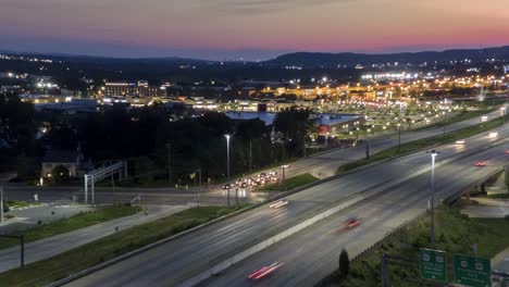 Aerial-timelapse,-hyperlapse-of-traffic-at-sunset-along-Route-30-in-Lancaster,-Pennsylvania,-USA,-near-Belmont-shopping-area,-drone-flying-in-reverse