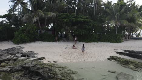 4K-Luftaufnahmen-Von-Freundinnen,-Die-Am-Strand-Einer-Kleinen-Tropischen-Insel-Auf-Den-Philippinen-Namens-Guyam-In-Siargao-Spielen.-Mädchen-Rennen-Und-Schlagen-Rad-Im-Sand