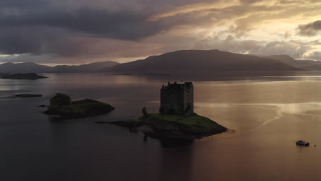 Eine-Luftaufnahme-Von-Castle-Stalker-Am-Loch-Laich,-Während-Die-Sonne-Untergeht