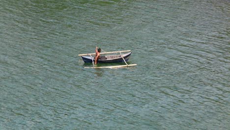 Erwachsener-Mann-In-Einem-Kleinen-Boot-Oder-Einer-Banca,-Der-Auf-Ruhigem-Gewässer-Ein-Netz-Zum-Fischfang-Verwendet