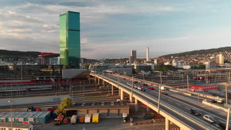 Aerial-drone-shot-flying-over-and-above-Hardbrücke-in-Zürich-Switzerland-at-sunset-in-summer