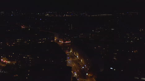 Aerial,-tracking,-drone-shot,-overlooking-the-Runeberginkatu-and-the-Toolo-cityscape,-in-downtown-Helsinki,-on-a-dark,-autumn-night,-in-Uusimaa,-Finland