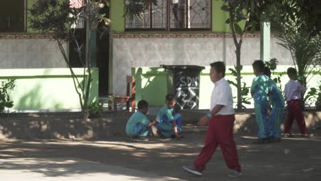 Un-Grupo-De-Escolares-Musulmanes-Jugando-En-El-Patio-De-La-Escuela-Y-Charlando-Entre-Ellos-En-Una-Aldea-Rural-De-Indonesia