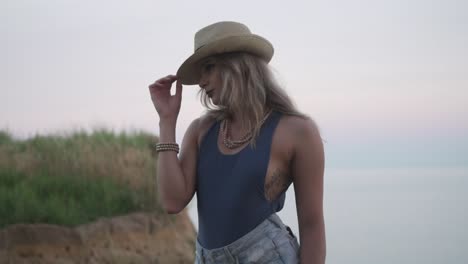 Side-Pose-Of-A-Beautiful-Woman-Near-The-Shallow-Sea-Water-In-Ontario,-Canada---Close-Up-Shot