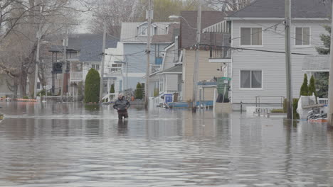 Un-Hombre-Camina-A-Través-De-Las-Secuelas-De-Una-Inundación-En-Un-Barrio-Residencial