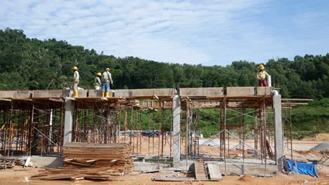 Construction-workers-installing-timber-form-works-and-rain-water-down-pipes-at-the-construction-site