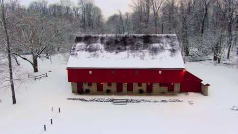 Drone-dolly-shot-of-red-barn-on-Rock-Ford-Plantation-in-Winter,-home-to-General-Edward-Hand,-winter-landscape-with-fresh-snow,-travel-concept,-heritage-sites