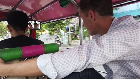 Tourists-riding-a-tug-tuk-through-Bangkok-on-route-to-their-destination