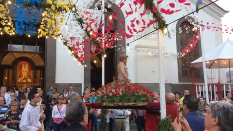 Procesión-Festiva-Religiosa-Cristiana-En-Honor-De-San-Juan-Bautista,-Los-Hombres-Llevan-La-Estatua-Y-Cientos-De-Personas-Caminan-Mientras-Rezan